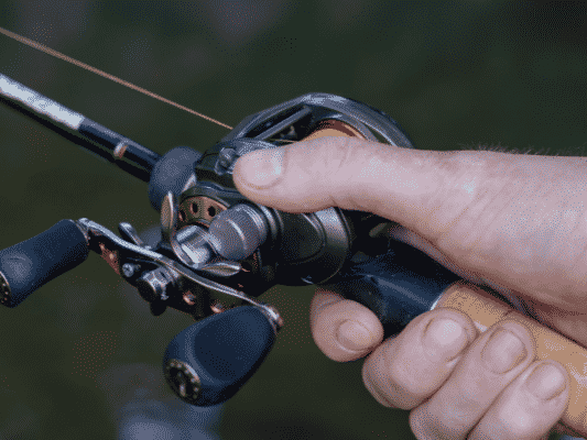 right hand holding a rod and baitcaster