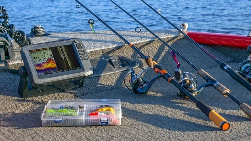 fish finder, tackle box, rod and reel on boat