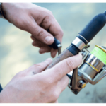 hand holding a fishing rod and spinning reel