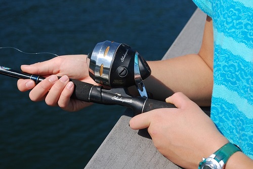 fisher holding spincast rod and reel