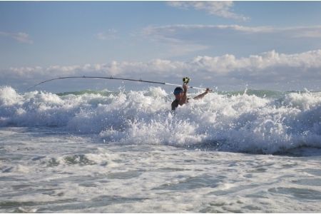 angler surf fishing during high tide