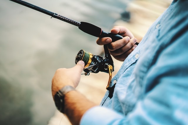 angler holding a spinning rod and reel