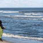 angler in waders surf fishing